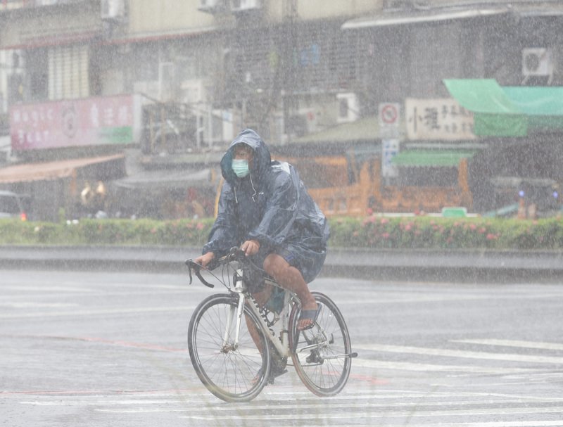 東北季風影響及對流發展旺盛，中央氣象局7日對5縣市發布大雨、豪雨及大豪雨特報，提醒北部及東部民眾要特別留意。圖為台北市信義區民眾穿雨衣騎乘腳踏車。中央社記者張新偉攝  111年10月7日 (圖：中央社)